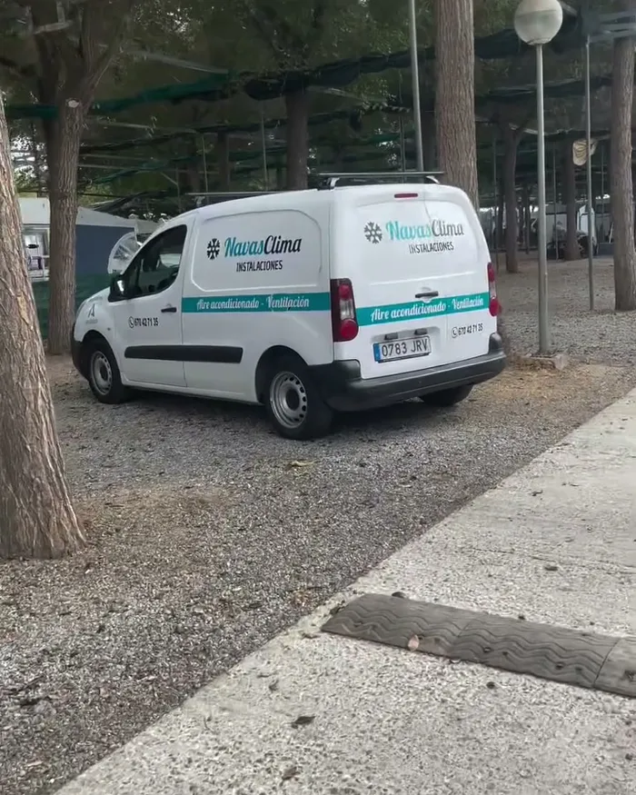 La furgoneta de Navas Clima aparcada entre los mobile homes de un camping